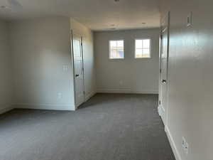 Carpeted empty room with baseboards