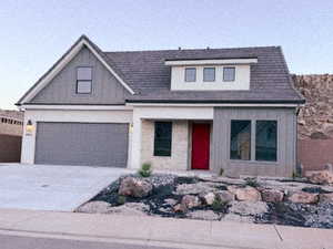 View of front of home featuring concrete driveway, covered porch, a garage, and board and batten siding