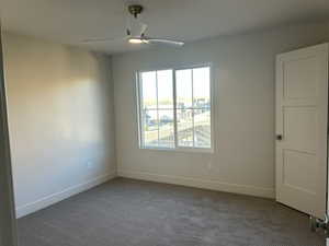 Unfurnished room featuring carpet flooring and ceiling fan