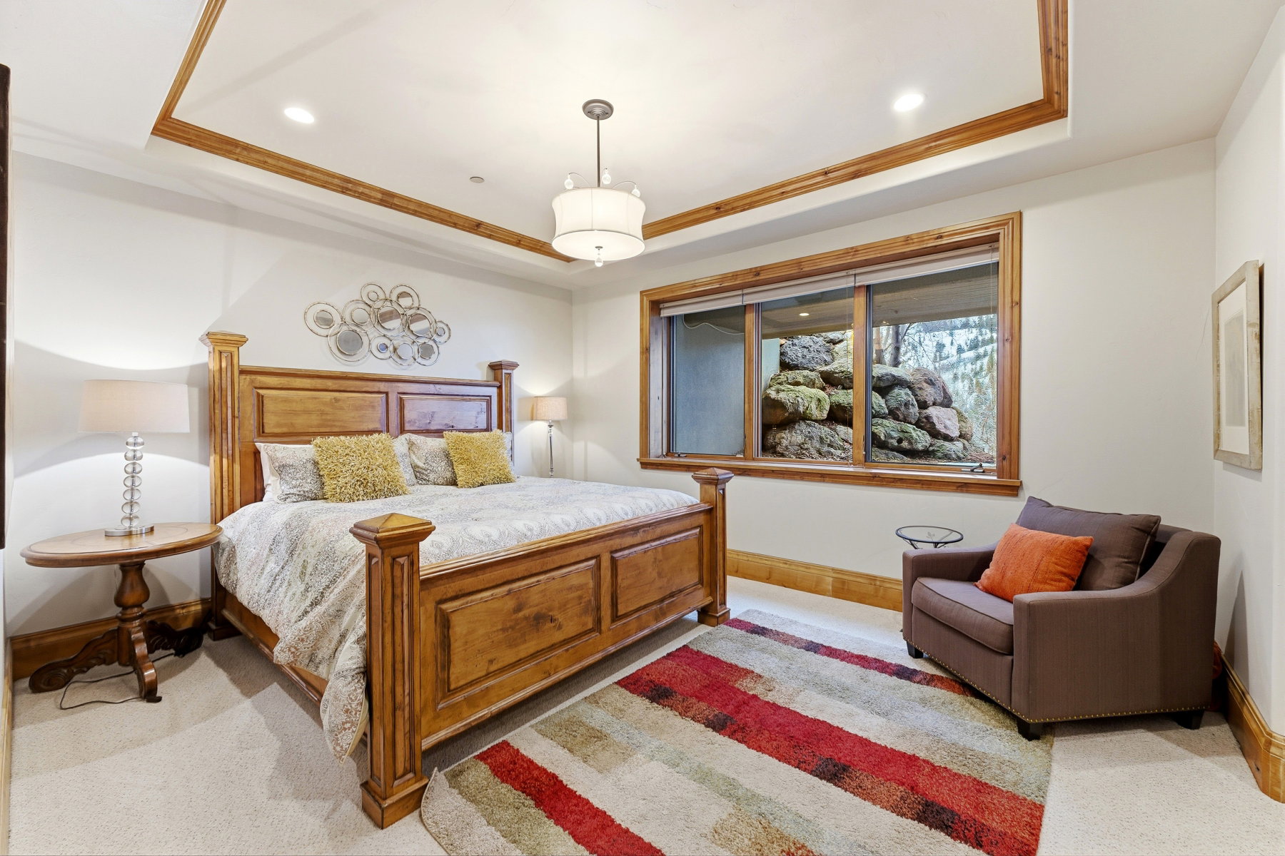 Bedroom featuring a tray ceiling, recessed lighting, ornamental molding, and light carpet