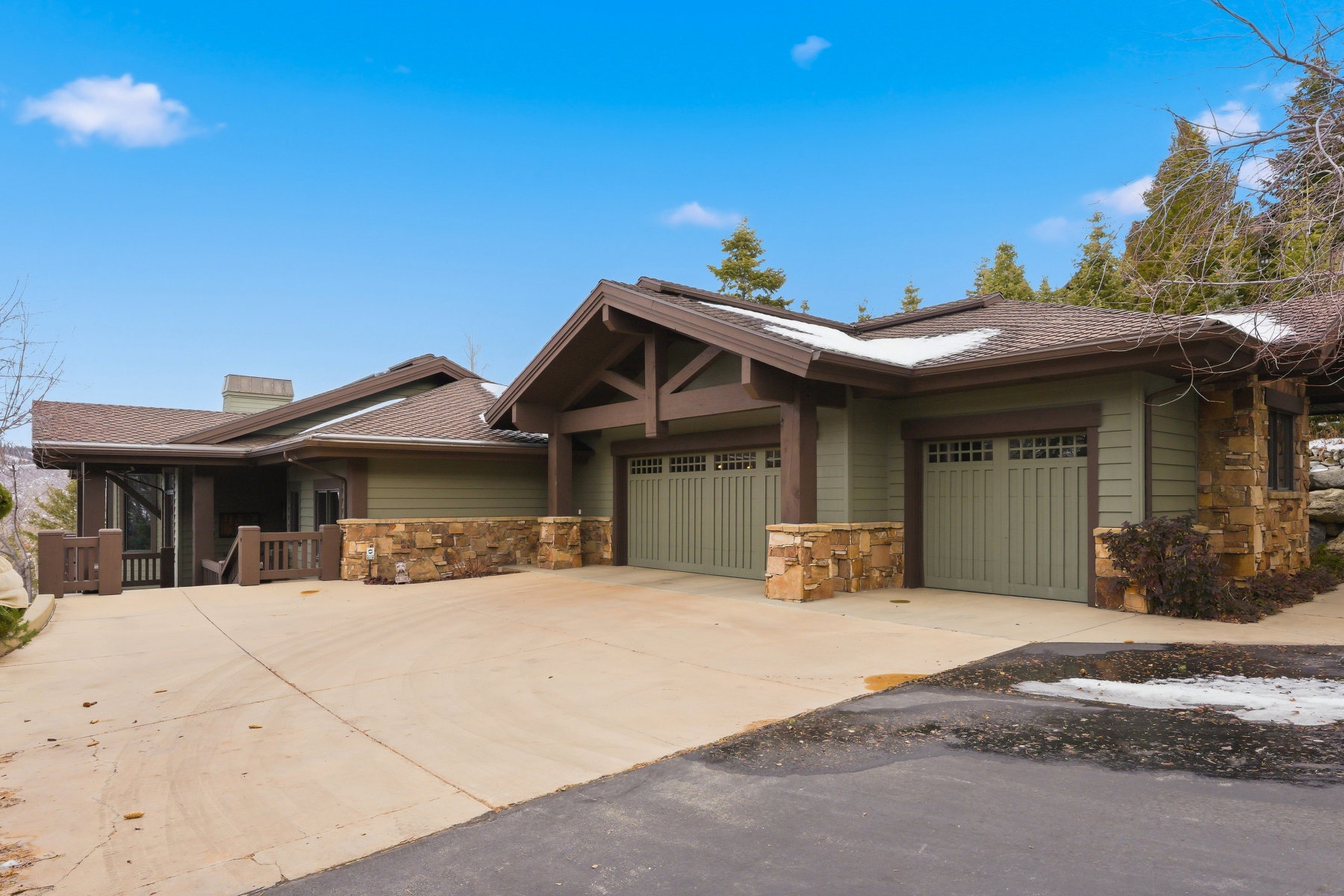 Craftsman house featuring stone siding, concrete driveway, an attached garage, and a chimney