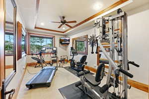 Exercise room with a raised ceiling, ceiling fan, crown molding, recessed lighting, and light colored carpet