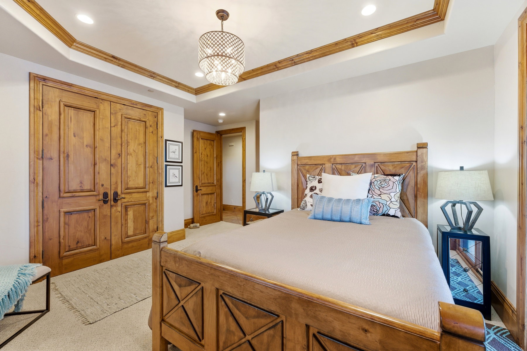 Bedroom with crown molding, a raised ceiling, recessed lighting, a chandelier, and a closet