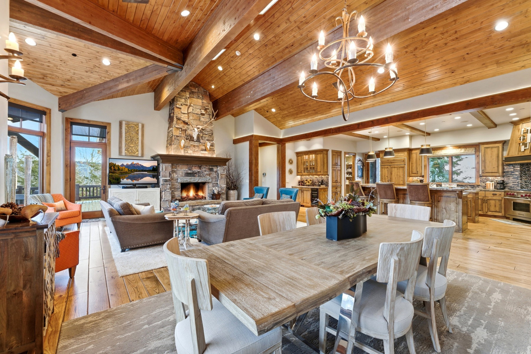 Dining space with a fireplace, a chandelier, a wooden ceiling with exposed beams, light wood-style flooring, and recessed lighting