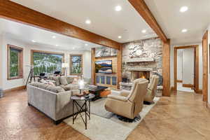 Living area featuring beam ceiling, a fireplace, and recessed lighting