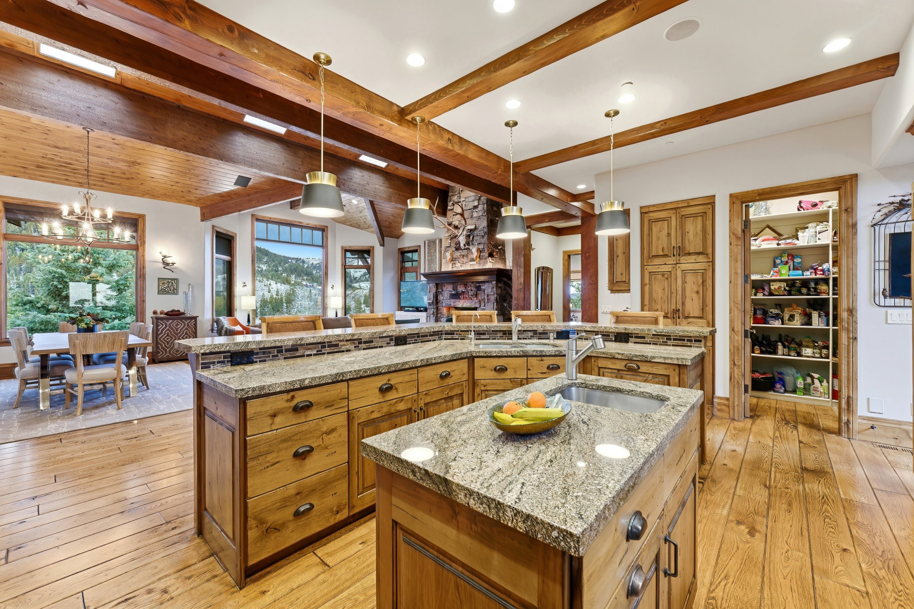 Kitchen with brown cabinetry, decorative light fixtures, light wood-style floors, beam ceiling, and recessed lighting
