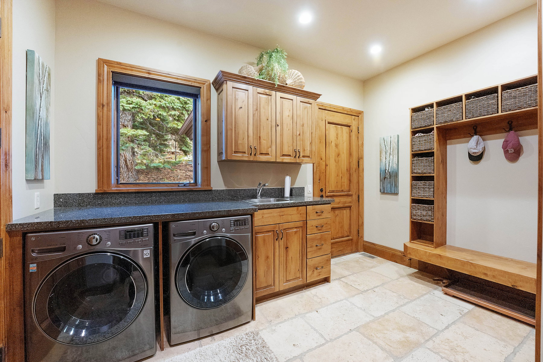 Laundry room featuring washer and clothes dryer, stone tile floors, and cabinet space