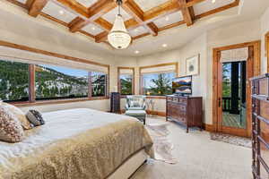 Bedroom with carpet flooring, a chandelier, coffered ceiling, multiple windows, and recessed lighting