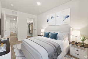 Bedroom with a spacious closet and light colored carpet