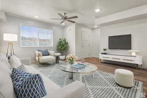 Living room with wood finished floors, ceiling fan, recessed lighting, and wooden walls