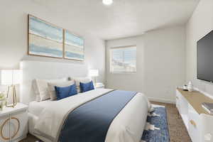 Bedroom with dark carpet and a textured ceiling