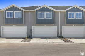 View of front of home with driveway, board and batten siding, and an attached garage