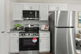 Kitchen with stainless steel appliances, white cabinetry, and tasteful backsplash