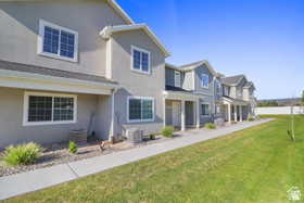 View of front of home featuring a front lawn, a residential view, stucco siding, and a porch