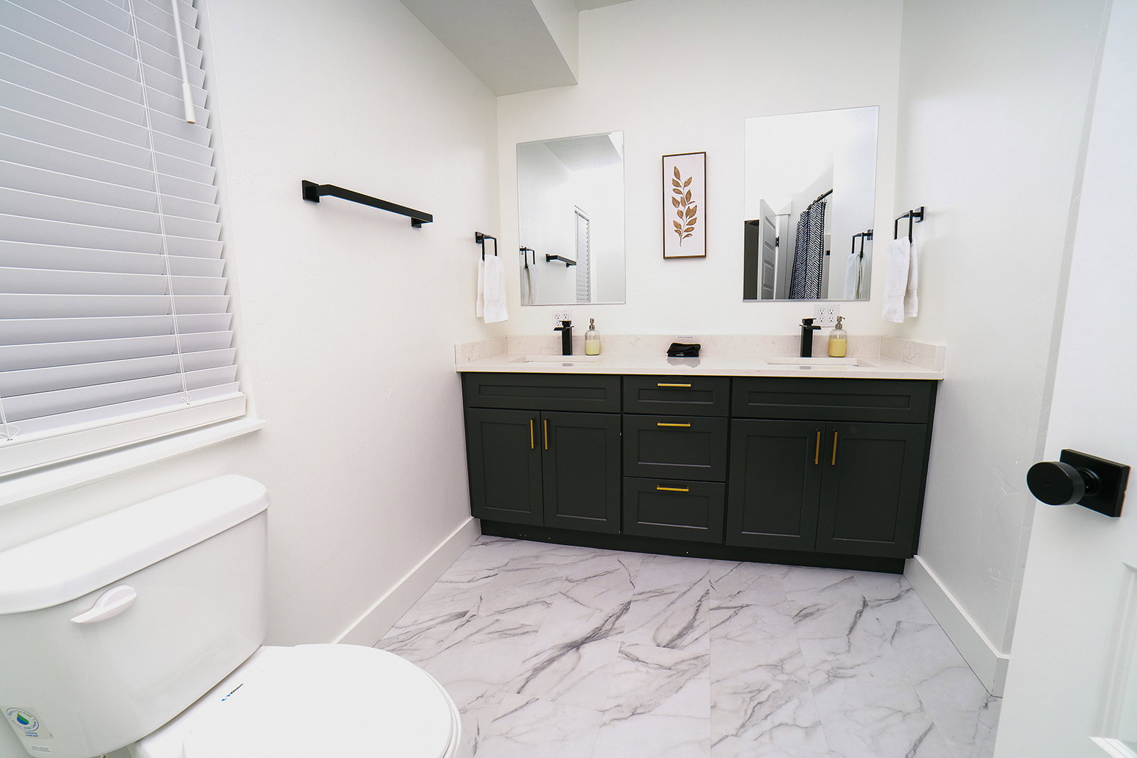 Bathroom with light marble finish flooring and double vanity