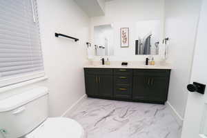 Bathroom with light marble finish flooring and double vanity