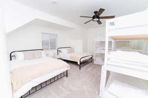 Bedroom with a ceiling fan, carpet, and lofted ceiling