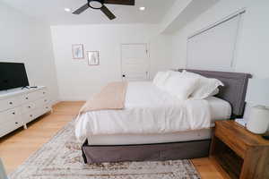 Bedroom featuring light wood-style flooring, a ceiling fan, and recessed lighting
