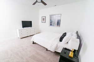 Carpeted bedroom featuring ceiling fan and baseboards