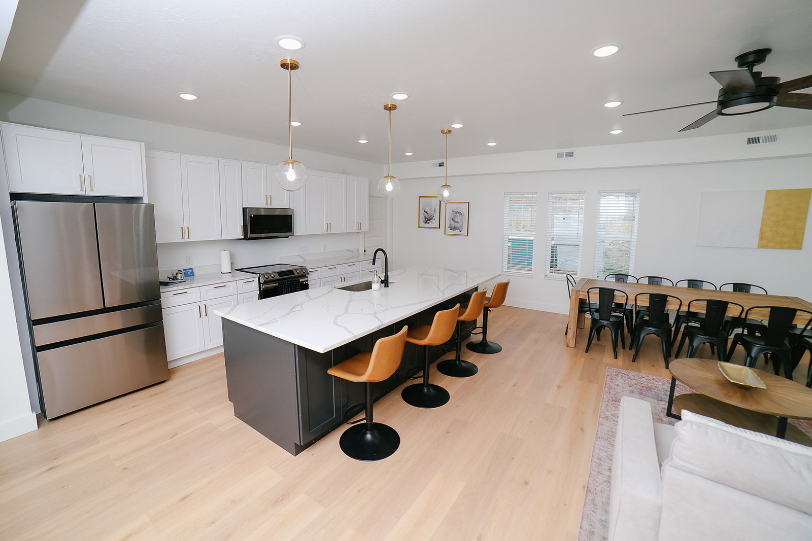 Kitchen with stainless steel appliances, decorative light fixtures, white cabinetry, a breakfast bar, and recessed lighting