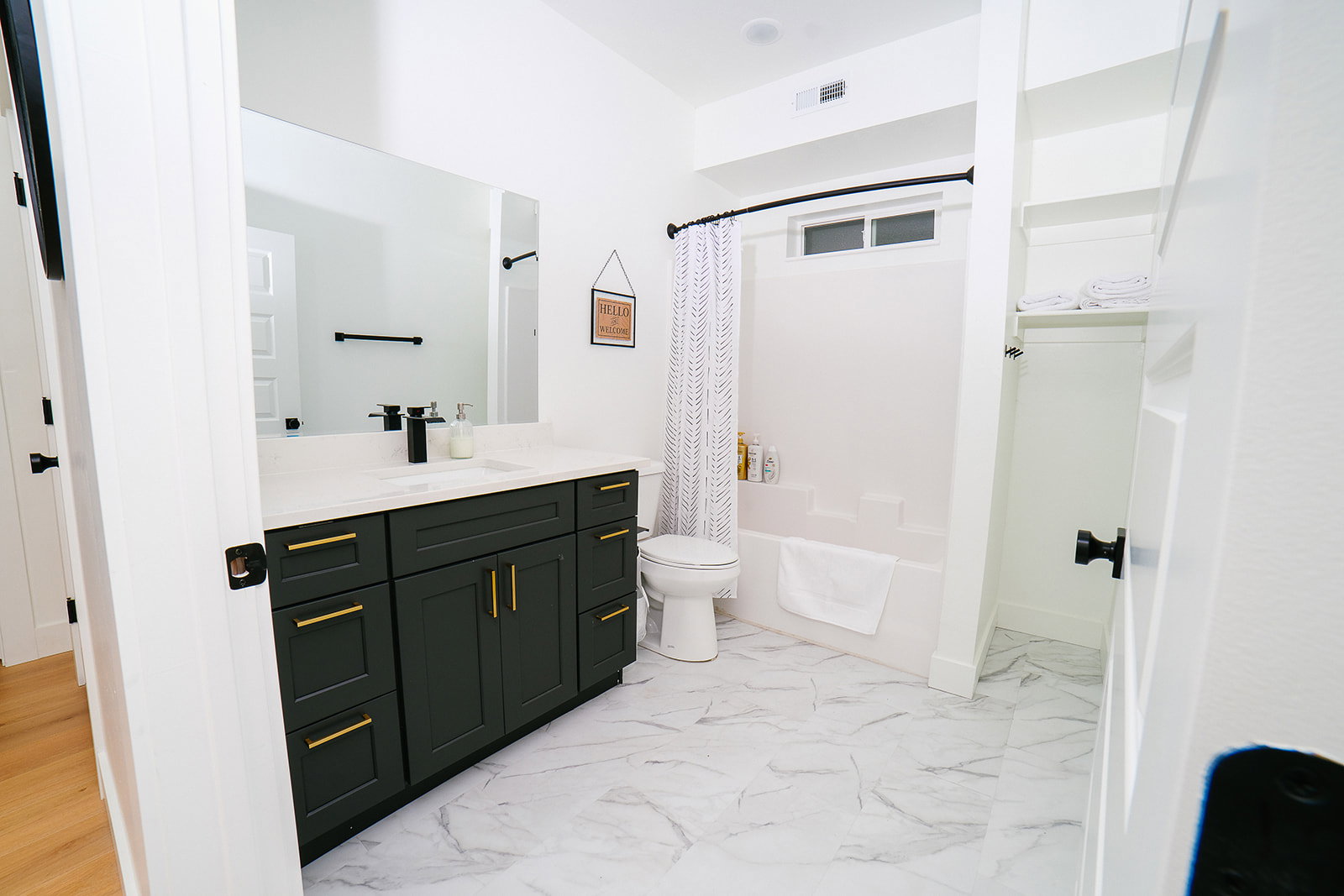 Bathroom featuring vanity, shower / tub combo, and light marble finish flooring