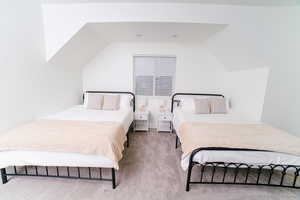 Carpeted bedroom featuring lofted ceiling