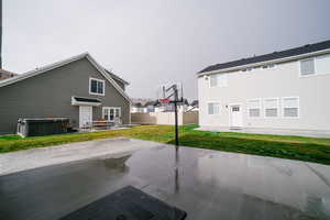 Rear view of property with a patio area and a hot tub