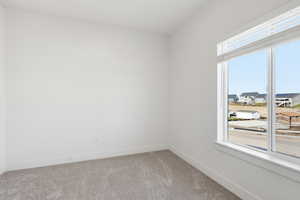 Spare room with light colored carpet and baseboards
