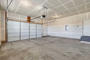 Garage with electric panel and a garage door opener
