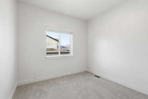 Carpeted empty room with baseboards