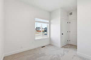 Spare room with baseboards and light carpet