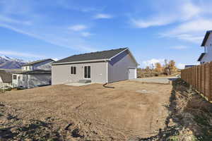 Rear view of house with a garage, a patio area, and dirt driveway
