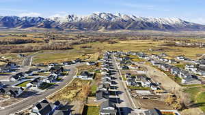 Aerial view of property and surrounding area with nearby suburban area and a mountainous background