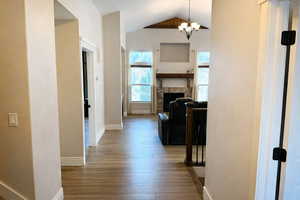 Hall with light wood-type flooring, hanging lights, and a high ceiling