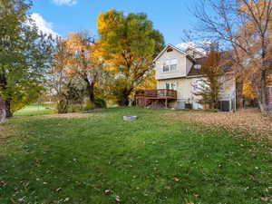 View of grassy yard featuring a wooden deck