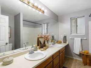Full bath featuring double vanity and a shower