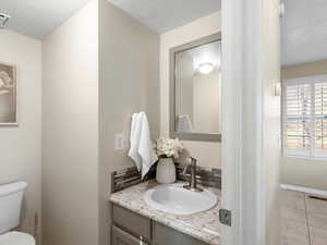 Half bath featuring vanity and tile patterned flooring