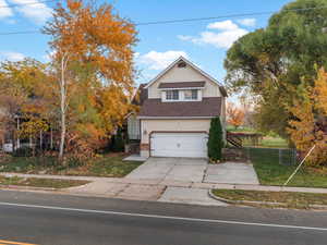 Traditional-style house with roof with shingles, concrete driveway, and an attached garage