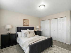 Carpeted bedroom featuring two closets and baseboards