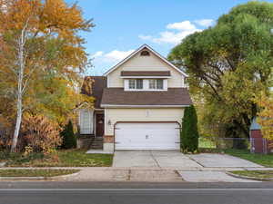 Traditional-style home with roof with shingles, concrete driveway, an attached garage, and brick siding