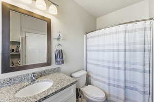 Full bath featuring curtained shower and vanity