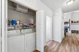 Laundry area featuring light wood-style floors and washing machine and dryer