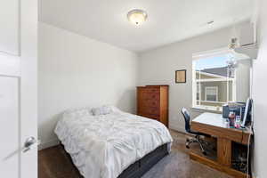 Carpeted bedroom featuring baseboards and an office area