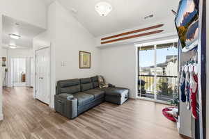 Living room with high vaulted ceiling and light wood-style floors