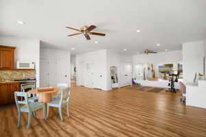 Dining space with ceiling fan, light wood-style floors, and recessed lighting