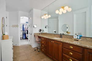 Bathroom featuring vanity, a spacious closet, and light tile patterned floors