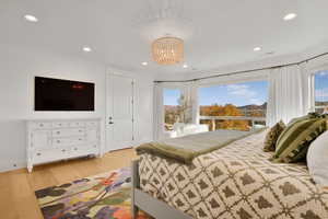 Bedroom featuring light wood finished floors, recessed lighting, and a chandelier