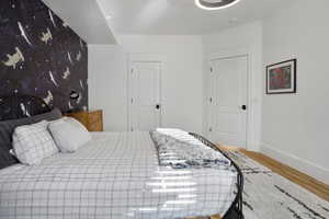 Bedroom with wood finished floors and baseboards