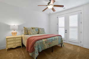 Carpeted bedroom with ceiling fan and baseboards