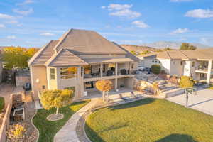 Back of house with a patio, a yard, stucco siding, a balcony, and a tile roof